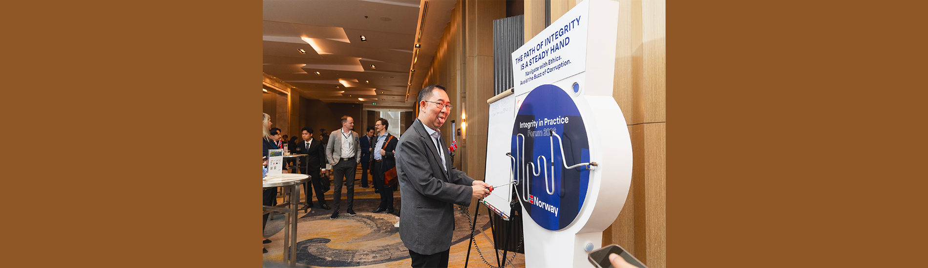 An attendee tests their steady hand at "The Path of Integrity" interactive game