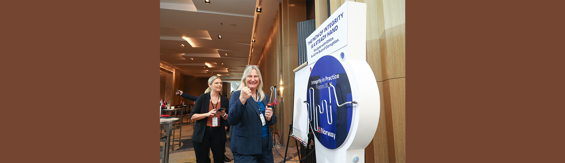 An attendee tests their steady hand at "The Path of Integrity" interactive game